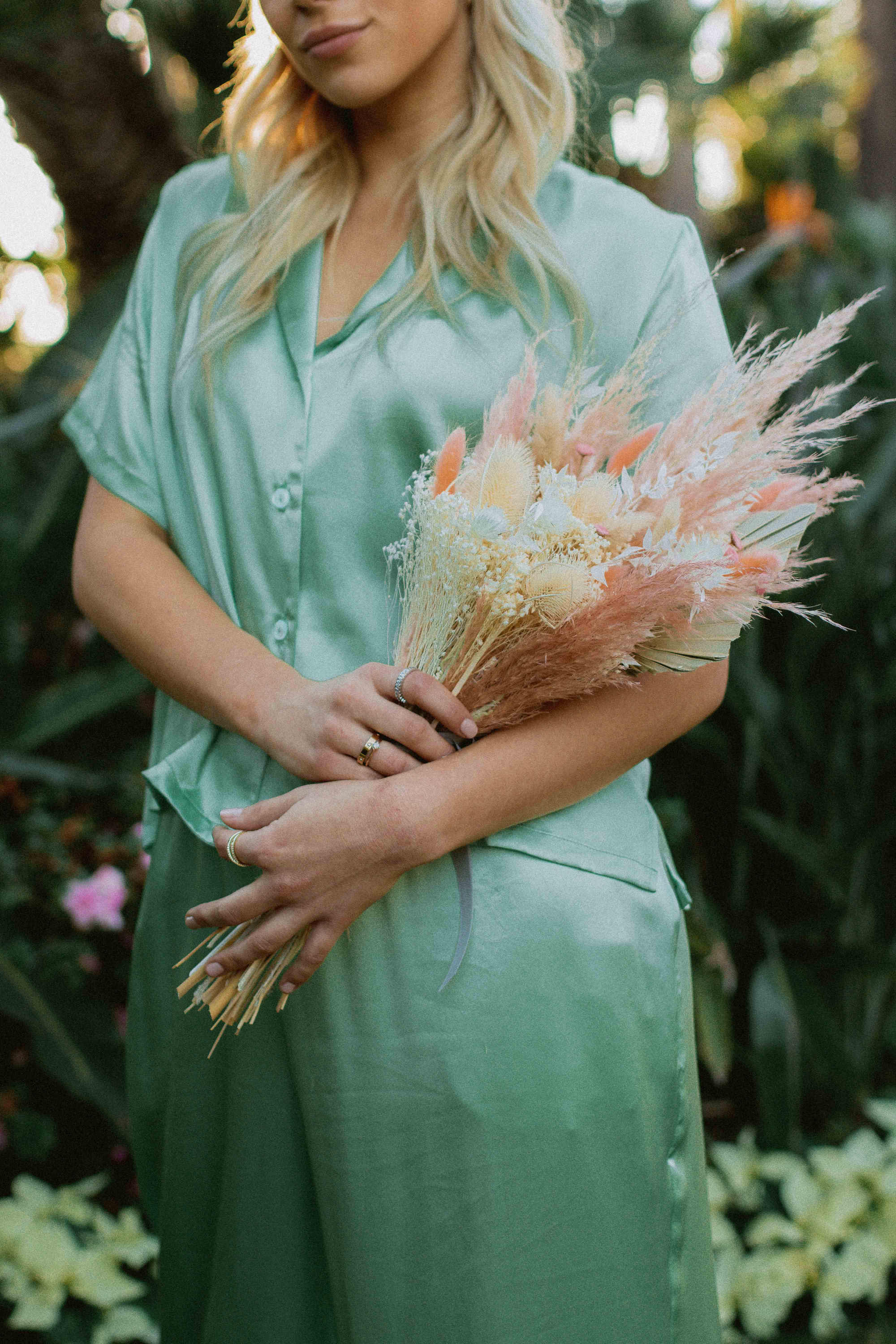 Woman on Green Silk Dress Carrying Bouquet of Wildflowers