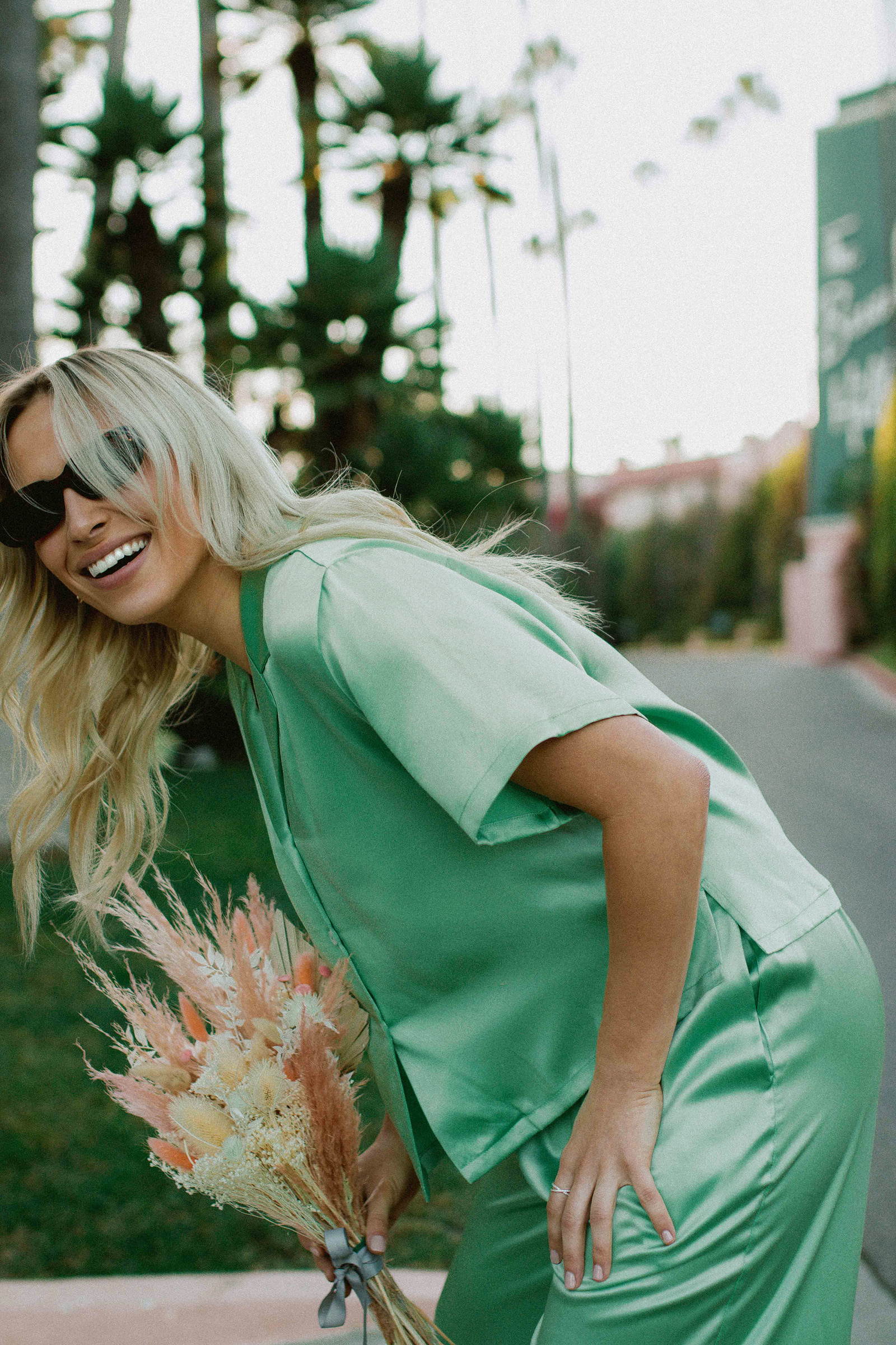 Woman Wearing Sunglasses Carrying Bouquet of Wildflowers