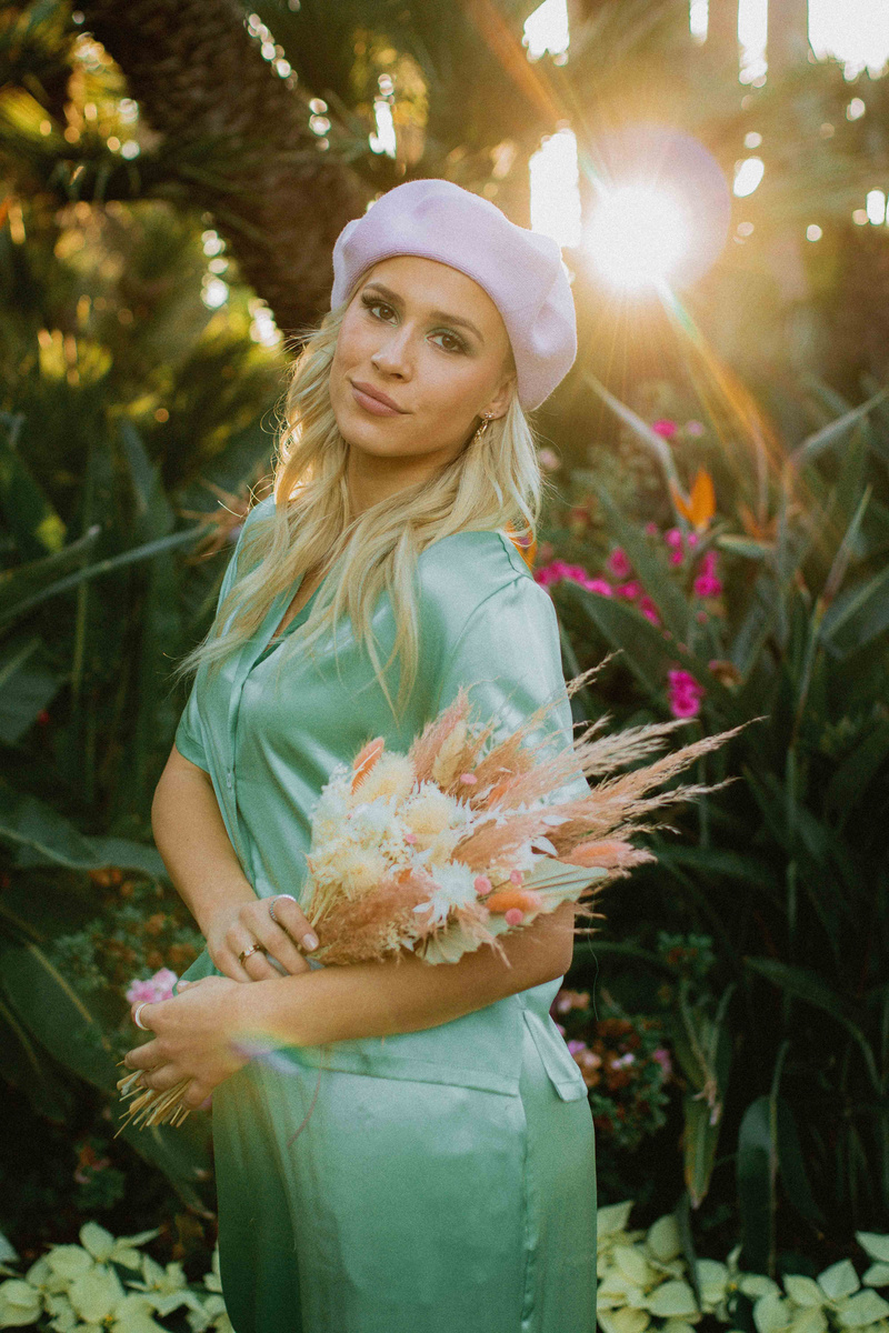 Woman Carrying Bouquet of Wildflowers with Plants on the Background